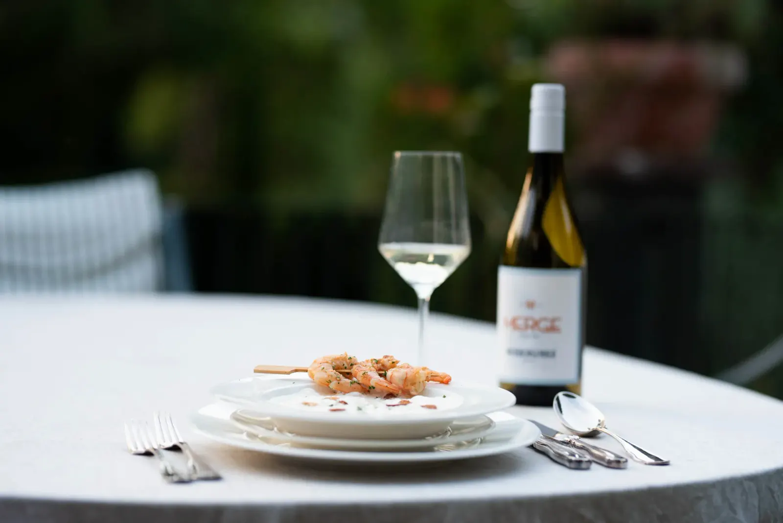 Gedeckter Tisch mit MERGE Wein und Garnelenspie&szlig;